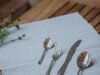 Six Things to Consider Before Buying Satin Silverware Hand examining the texture quality of a satin finish stainless steel fork - ChopChic.com
