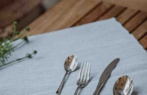 Six Things to Consider Before Buying Satin Silverware Hand examining the texture quality of a satin finish stainless steel fork - ChopChic.com