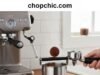 What Is a Coffee Knock Box and Why You Need One _A barista knocking a spent espresso puck into a stainless steel coffee knock box, keeping the espresso station tidy and grounds-free.