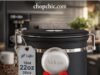The Amazon King: Is the Veken Coffee Canister Actually Good? (Review) _A Veken stainless steel coffee canister with a date tracker on the lid and a side window, displaying stored coffee beans and the CO2 release valve mechanism.