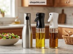 The 4 Best Oil Sprayers for Air Fryers A side-by-side display on a kitchen counter featuring four distinct reusable oil sprayers a brushed aluminum Misto, a BPA-free Evo trigger bottle, a glass 2-in-1 TrendPlain dispenser, and a clear glass YARRAMATE mister—lined up directly in front of an open, non-stick air fryer basket.