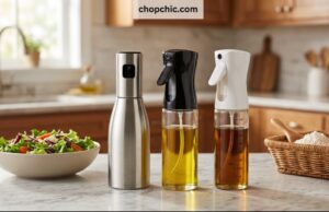 The 4 Best Oil Sprayers for Air Fryers A side-by-side display on a kitchen counter featuring four distinct reusable oil sprayers a brushed aluminum Misto, a BPA-free Evo trigger bottle, a glass 2-in-1 TrendPlain dispenser, and a clear glass YARRAMATE mister—lined up directly in front of an open, non-stick air fryer basket.