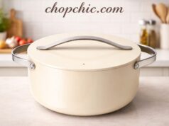 Caraway Dutch Oven Review: Safe for Sourdough Baking? A sleek, sage green Caraway ceramic-coated cast aluminum Dutch oven resting on a marble kitchen island, its pristine non-stick interior exposed next to a heavily floured, raw sourdough boule waiting to be baked.