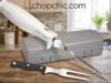 Hamilton Beach Electric Knife Review: The Ultimate Carving Multi-Tool A close-up of a stainless steel Hamilton Beach electric knife effortlessly gliding through a thick, crusty sourdough loaf on a wooden cutting board, specifically highlighting the dual reciprocating serrated blades in motion.