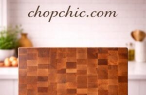 John Boos CCB Series Review: Heavyweight Cutting Board A massive, 2.25-inch thick John Boos CCB Series end-grain chopping block securely positioned on a stainless steel prep station, showcasing its iconic checkerboard wood pattern and heavy, immovable profile beneath a professional butcher's cleaver.