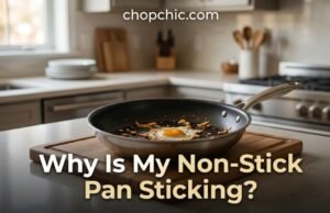 Why Is My Non-Stick Pan Sticking? (And How to Fix It) A heavily used non-stick skillet showing stubborn, burnt-on food residue, positioned on a kitchen counter next to a glass bowl of white vinegar and a measuring spoon of baking soda.
