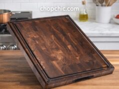Sonder LA Alfred Review: Ultimate Walnut Wood Cutting Board A thick, dark walnut end-grain Sonder Los Angeles cutting board resting on a bright countertop, showcasing a high-end Japanese Santoku knife alongside the board's integrated sorting compartments and deep juice groove.