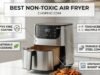 Best Non-Toxic Air Fryer: 4 Tech-Forward Picks for a Clean Kitchen A professional comparative photograph of three non-toxic air fryer types on a modern kitchen counter: a model with a transparent glass basket showing crispy sweet potato fries, a model with a white ceramic-coated interior, and a sleek stainless steel toaster-oven style air fryer. The lighting is bright and clean. A website watermark is positioned at the very top center of the frame.