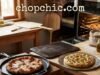 The Best Non-Toxic Pizza Pan for Oven: The Quest for the Perfect Crispy Crust A comparative photograph in a warm home kitchen, featuring three distinct non-toxic pizza baking vessels. A professional baking steel plate sits on an oven rack inside a partially open oven. Next to it on a wooden counter, a seasoned cast iron pizza pan holds a fresh margherita pizza, and a polished circular stainless steel pan sits nearby. The lighting is warm and natural, highlighting the metallic textures of the safe cookware. A website watermark is positioned at the very top center of the frame.