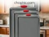 Boxiki Kitchen Carbon Steel Review: Engineering the High-Heat Bake An extreme close-up of a dark gray Boxiki Kitchen heavy-gauge carbon steel baking sheet remaining perfectly flat inside a 420°F oven while evenly roasting vegetables, featuring a diagrammatic overlay illustrating how the thick rim geometry resists thermal torsion and eliminates warping.