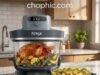 Modular Glass Engineering: Ninja Crispi Pro 6-in-1 Analysis A technical photography of the 1800W Ninja Crispi Pro portable cooking system in a modern kitchen, with the sleek heating pod mounted atop the durable 6-quart borosilicate glass pot. Golden-brown roasted potatoes are visible inside the transparent vessel. Heat waves are subtly illustrated rising from the glass to emphasize thermal performance. Natural lighting, high-end appliance aesthetic. A watermark logo is positioned at the top center of the visual.