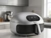Typhur Dome 2 Review: The Quiet Physics of Professional Air Frying A technical photograph in a modern, sunlit kitchen shows the sleek, open Typhur Dome 2 appliance, highlighting its dark, matte ceramic-coated interior. Two infographic overlays are visible: one with red graphics and a laser dot showing the infrared dual-heat system, and another with a green checkmark indicating the certified food-safe ceramic lining. A digital thermometer displays a high-temperature reading nearby.